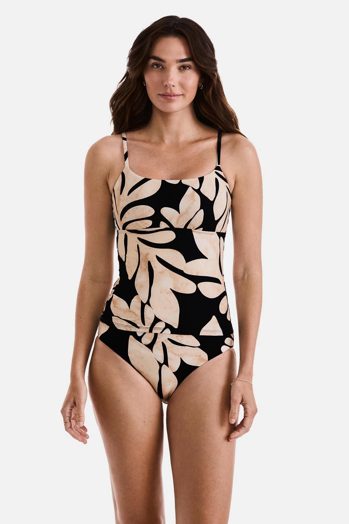 Woman wearing a large tan and black leaf printed tankini top with matching swim bottoms