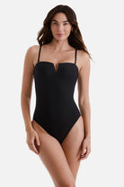 Woman wearing a black one-piece swimsuit with a sweetheart neckline