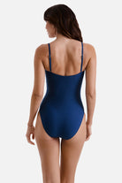 Woman faced away wearing a dark blue one-piece swimsuit
