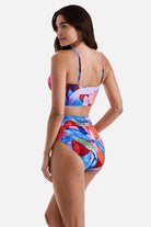 Woman turned left wearing a multicolored abstract printed midkini swim top with matching swim bottoms