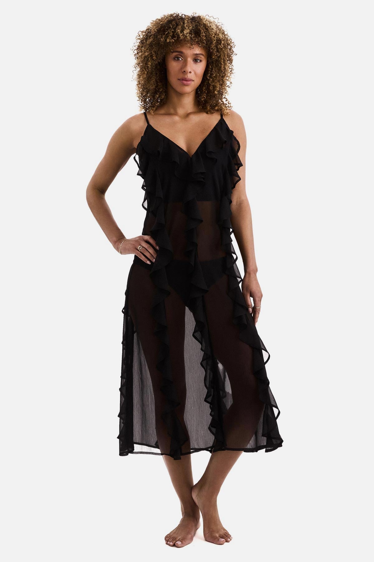 Woman wearing a black sheer ruffled swim dress cover up