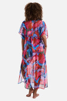 Woman turned away wearing a multicolored abstract printed sheer swim cover up