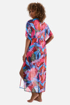 Woman turned left wearing a multicolored abstract printed sheer swim cover up