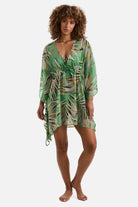 Woman wearing a multicolored leaf print sheer swim cover up