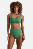 Woman wearing a green ribbed bralette swim top with matching swim bottoms