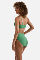 Woman turned left wearing a green ribbed bralette swim top with matching swim bottoms