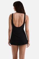 Woman turned away wearing a black swim dress