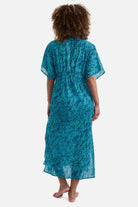 Woman turned away wearing a blue abstract printed caftan swim cover up
