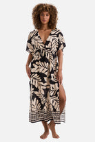 Woman wearing a black and tan palm leaf printed swim dress cover up