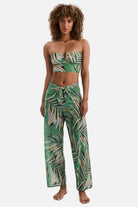 Woman wearing a multicolored leaf printed swim cover up pants with a matching midkini top