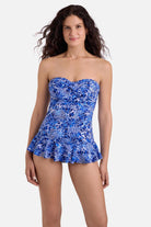 Woman wearing a blue and white floral printed skirted one-piece swimsuit