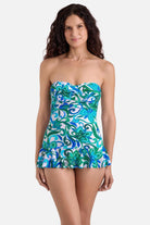 Woman wearing a blue and green floral printed skirted one-piece swimsuit