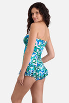 Woman turned left wearing a blue and green floral printed skirted one-piece swimsuit